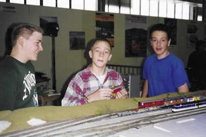 Trois jeunes devant une gare